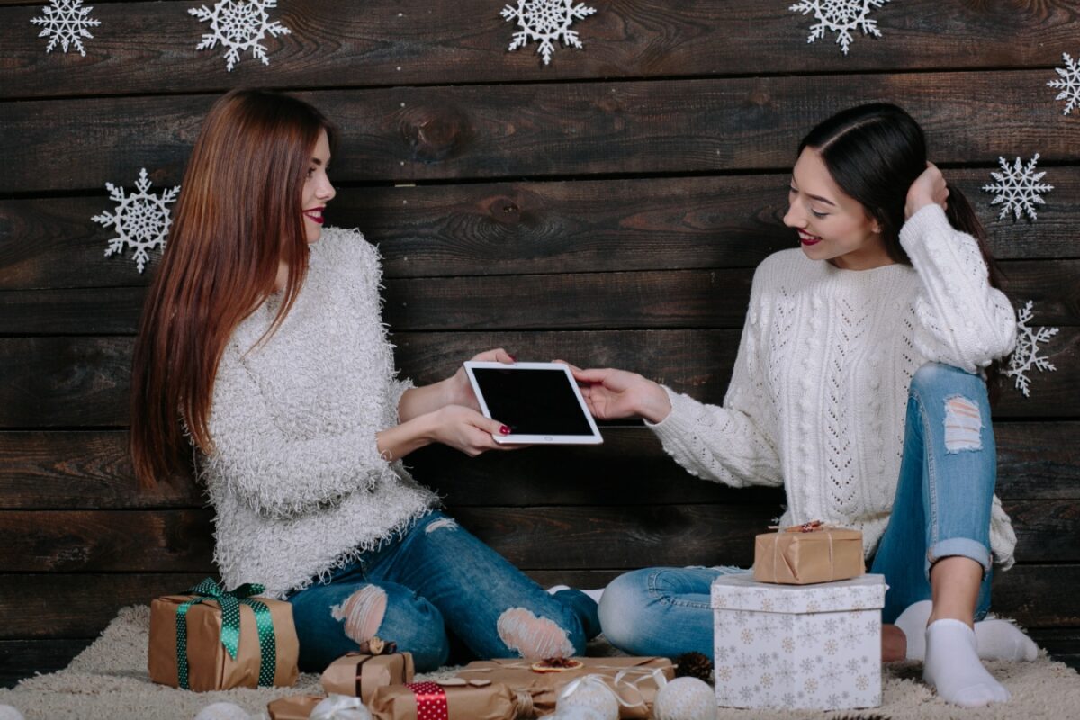 https://ticktocktech.com/wp-content/uploads/2022/11/two-beautiful-women-sitting-floor-with-tablet-gifts-christmas-1-1-1200x800.jpg